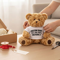 Teddy bear wearing a custom white t-shirt being packed into a gift box with ribbon and a gift tag