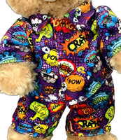 A teddy bear wearing a colorful, patterned outfit with various pop art-style speech bubbles and text.