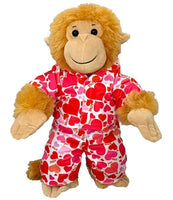 A stuffed monkey wearing a red and white heart-patterned pajama outfit.