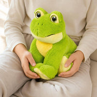 A person is sitting on a couch, holding a green stuffed frog toy.