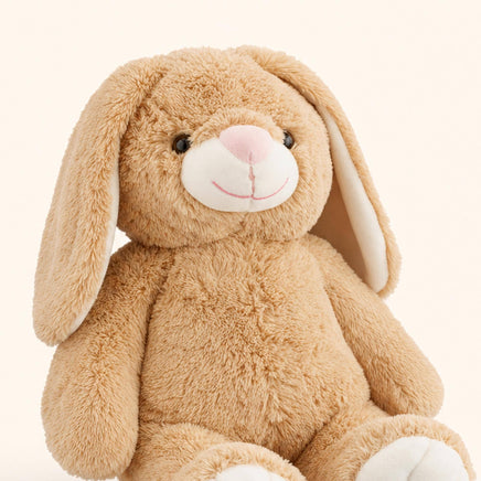 A brown stuffed bunny toy with large ears and a pink nose sits against a light background.