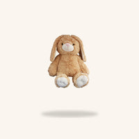 A brown stuffed bunny toy is floating in the air against a plain white background.