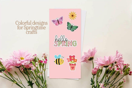 a pink card with colorful designs and illustrations, surrounded by pink flowers and a bee.