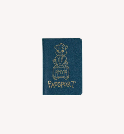 The image is a blue passport cover with a gold illustration of a bear sitting on a suitcase.