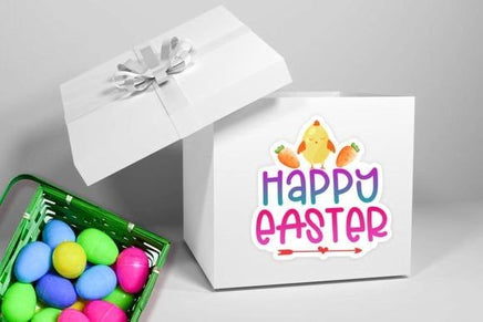a white gift box with a "Happy Easter" sticker on it, along with a green basket filled with colorful Easter eggs.