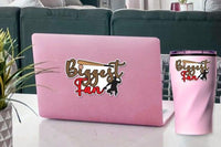 a pink laptop with a sticker on it, placed on a table next to a pink thermos.