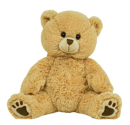 A large, light brown teddy bear sitting on its hind legs with its front paws resting on the ground.