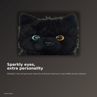 A close-up of a black plush toy with large, colorful eyes, described as having a teal and gold eye color.