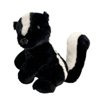 A black and white stuffed skunk toy is sitting on a white background.