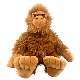 A brown plush toy of a large primate, possibly a gorilla or an orangutan, sitting on its hind legs with its front paws resting on the ground.
