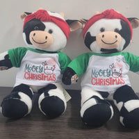 Two stuffed teddy bears sitting next to each other, wearing Christmas-themed shirts and red bandanas.