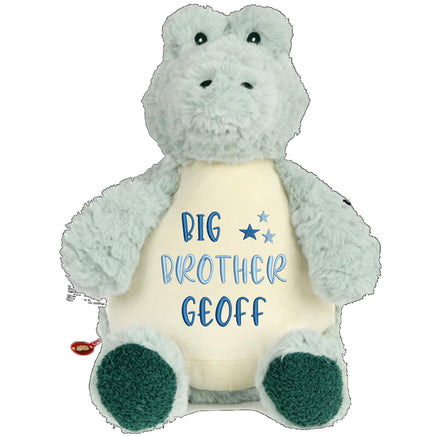 A stuffed toy dinosaur wearing a yellow shirt with the text "BIG BROTHER GEOFF" printed on it.