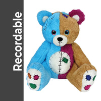 A colorful teddy bear with a blue and brown body, white paws, and various patches and decorations on its fur.
