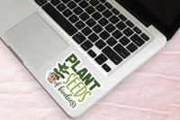 A laptop with a sticker on the palm rest that says "PLANT SEEDS of kindness".