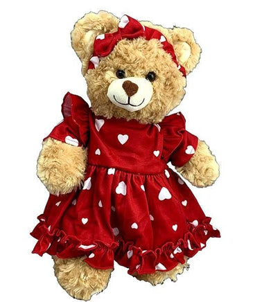 A teddy bear wearing a red dress with white hearts on it.