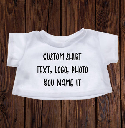 A white t-shirt with text printed on it, placed on a wooden surface.