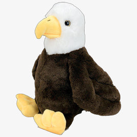 A stuffed eagle toy with a brown body and white head, sitting on its hind legs.