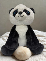A stuffed panda bear toy sitting on a white surface.