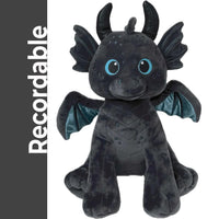 A plush toy of a dragon-like creature with large blue eyes and black wings.