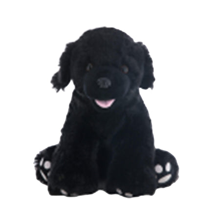 A black Labrador retriever stuffed animal sitting on the ground.