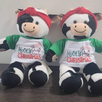 Two stuffed teddy bears sitting next to each other, wearing Christmas-themed shirts and red bandanas.