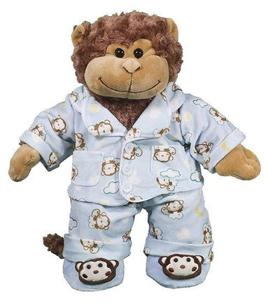 A stuffed toy monkey wearing a blue pajama outfit with monkey faces and clouds printed on it.