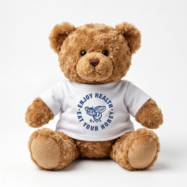 A brown teddy bear wearing a white t-shirt with the text "Enjoy HEALTHY EAT YOUR HONEY" printed on it.