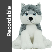 A plush toy of a husky dog with a gray and white fur coat and blue eyes, sitting on its hind legs.