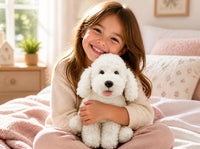 Smiling girl on a cozy bed hugging a white poodle stuffed animal from the Baker's Bears 16 inch DIY plush kit